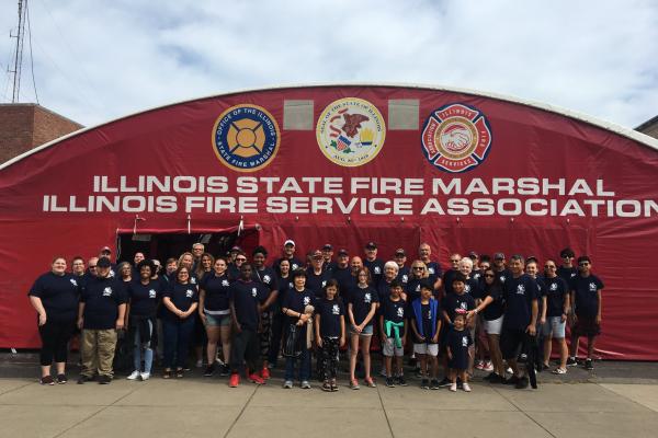 IFSA volunteers pose outside the Illinois State Fire Marshall tent at the State fair