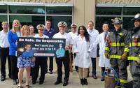 Fire Officials & Medical Experts holding up sign at Live Demo Showing Dangers of Fireworks