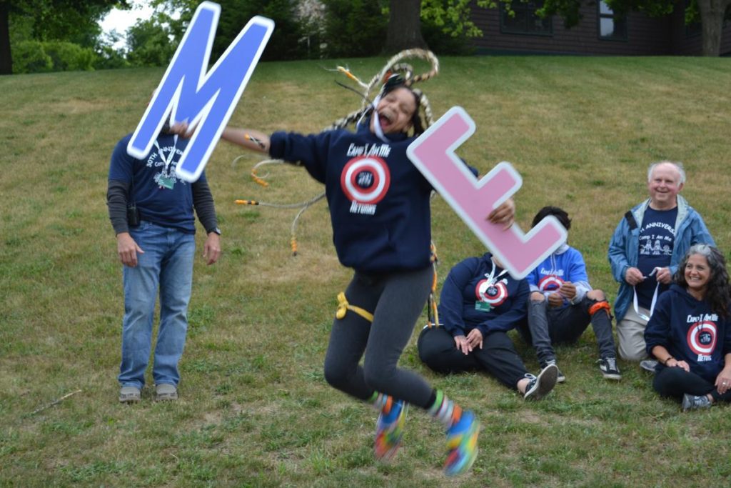 Camp I Am Me camper holding letter shaped signed that spell "ME"