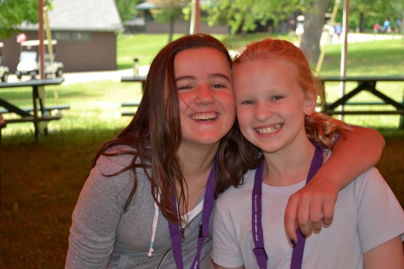 Two young girls posing for a picture of camp friends