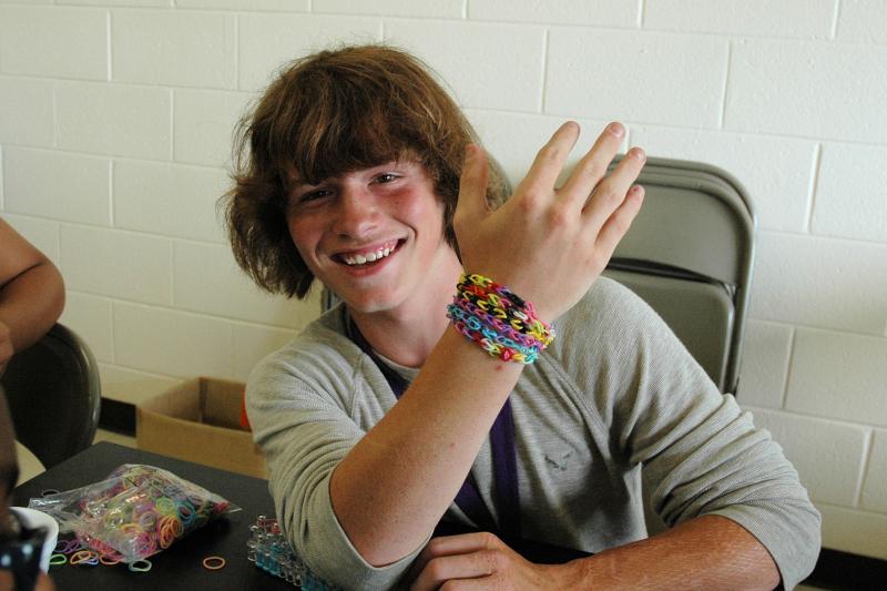 Camper proudly displays crafted bracelet with a smile