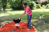 Lady grilling at a charcoal bbq