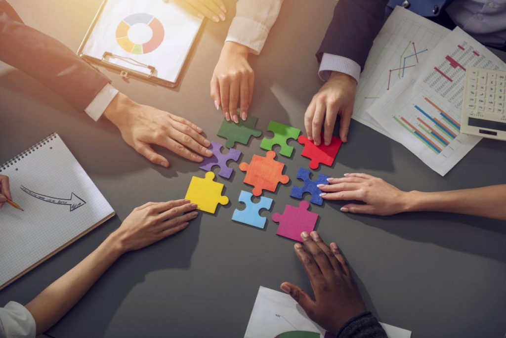 Office workers collaborating to assemble puzzle pieces