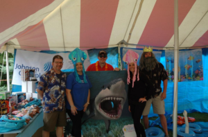Staff dressing up with undersea decorations at Johnson Controls booth at the IFSA Fun Fair